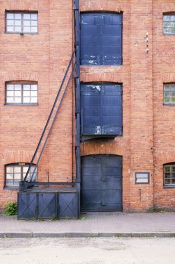 Kırmızı tuğla bina ve üç metal kapılar ve pencereler eski stil