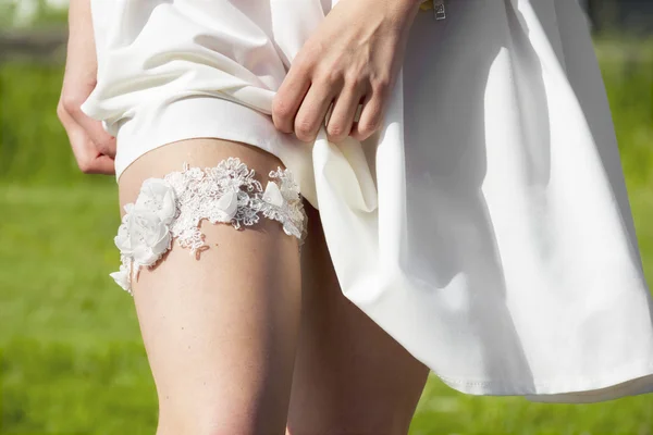 Beautiful wedding garter on the leg of a bride — Stock Photo, Image