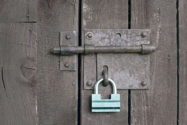 Green lock on a grey wooden door — Stock Photo, Image