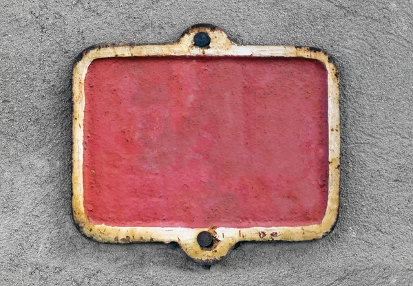 Placa enferrujada vermelha metálica velha em uma parede de estuque — Fotografia de Stock