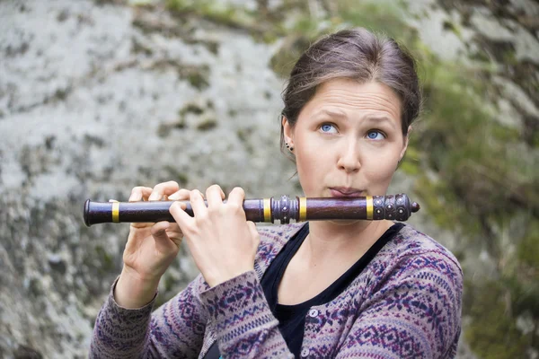 Женщина играет на индийской деревянной флейте — стоковое фото