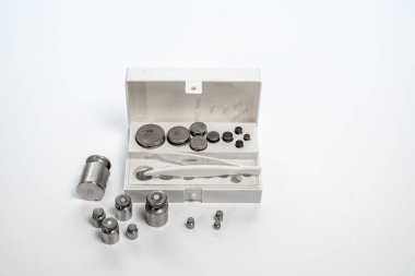 Beyaz arka planda ağırlıkları olan beyaz plastik bir kutu. Kapat..