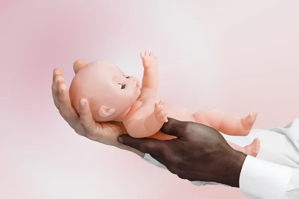 White and black man's hand holding a baby doll