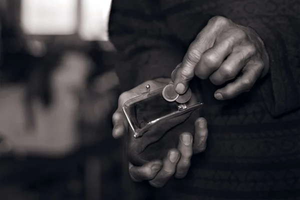 Old man's hands putting coins to a wallet — Stock Photo, Image