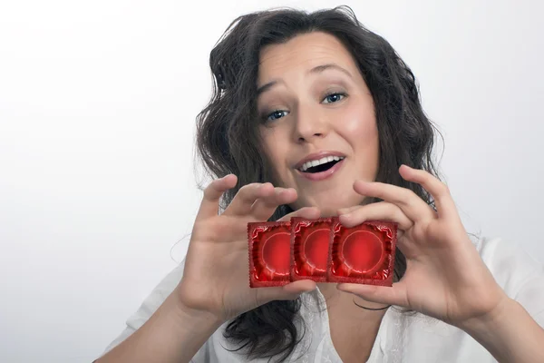 Chica con tres paquetes de condón rojo —  Fotos de Stock