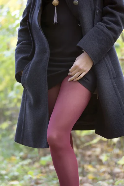 Ragazza in cappotto nero e calze rosse — Foto Stock