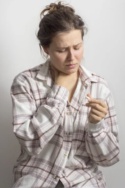 Mädchen mit Halsschmerzen und Tablette in der Hand — Stockfoto