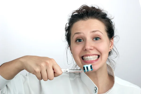Chica sonriente con un cepillo de dientes verde rojo azul —  Fotos de Stock