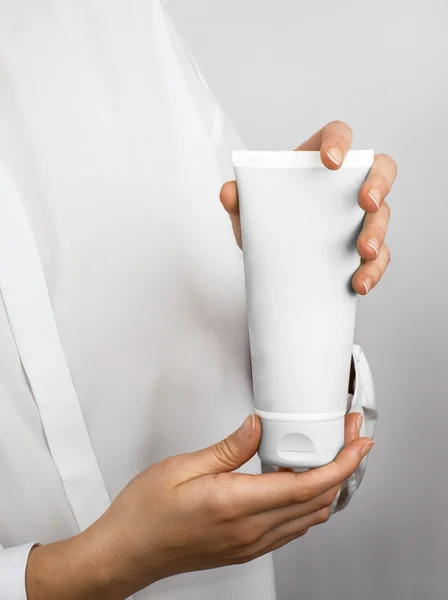 Girl's hands with a white tube — Stock Photo, Image