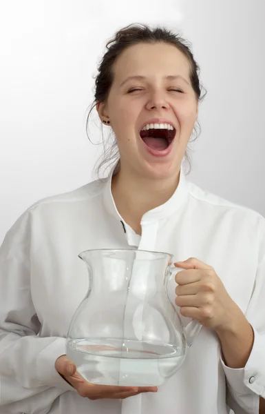 Chica sonriente con la boca abierta y una jarra con agua — Foto de Stock