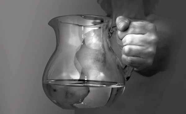 Man's hand with a pitcher of water in it — Stock Photo, Image