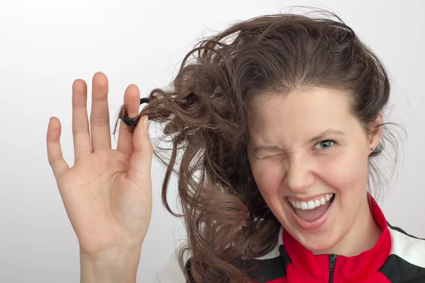 Portrait of a girl with one eye closed and hand preening hair — Stock Photo, Image