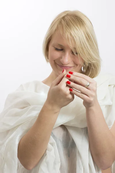 Jeune femme souriante avec un chiffon blanc et des ongles rouges — Photo