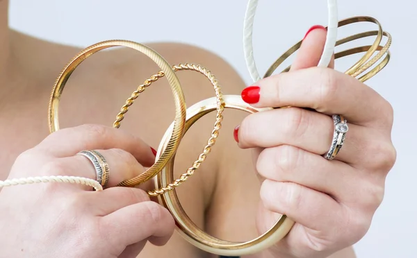 Woman's hands with gold bracelets — Stock Photo, Image