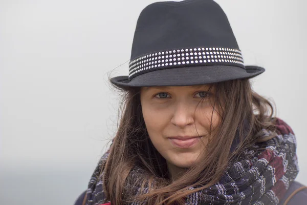 Leende flicka med en svart hatt — Stockfoto