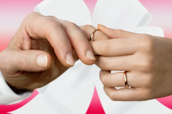 La mano de una mujer poniéndose un anillo de bodas en el dedo de un hombre — Foto de Stock