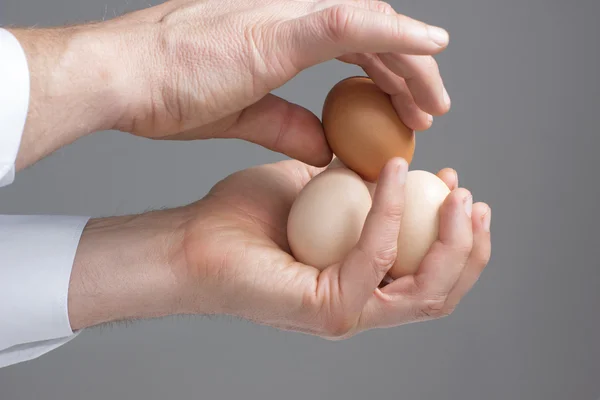 Четыре куриных яйца в мужских руках — стоковое фото
