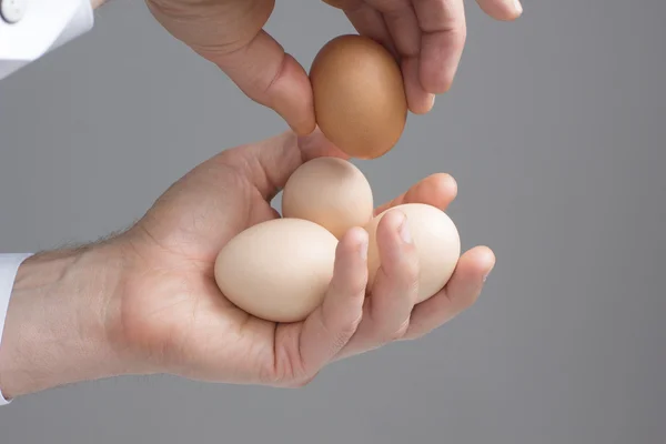 Четыре куриных яйца в мужских руках — стоковое фото