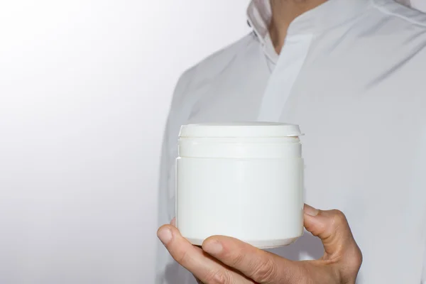 Mannen hand met een witte plastic container — Stockfoto