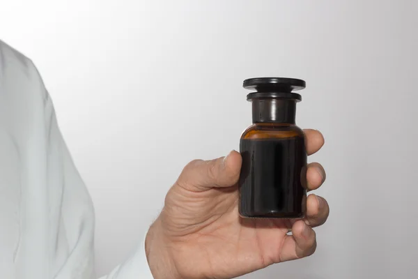 Men's hand with a dark glass bottle — Stock Photo, Image