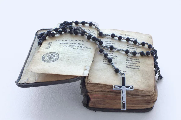 Libro de oraciones antiguo y un rosario negro en él — Foto de Stock