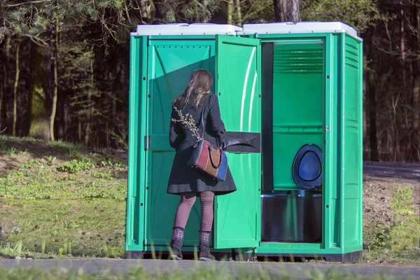 Girl at a portable toilets at an outdoor — Stock Photo, Image