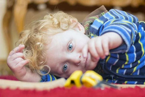 Liten pojke leker med leksak på golvet — Stockfoto