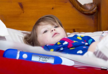 Elektronik termometre ve küçük bir hasta kız 