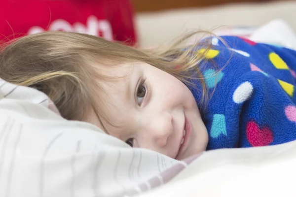 Niña en una cama — Foto de Stock