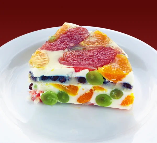 Pièce d'un gâteau à la gelée colorée aux fruits — Photo