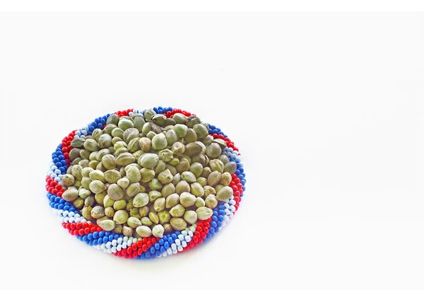 Sementes de cânhamo em uma pulseira de cores da bandeira — Fotografia de Stock