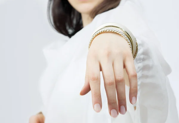 Mädchenhand mit goldenen Armbändern — Stockfoto