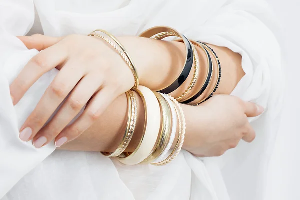 Meisje handen met gouden armbanden — Stockfoto