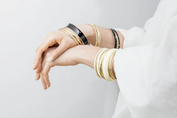 Girl's handen met gouden armbanden — Stockfoto