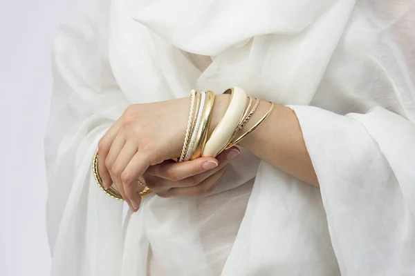 Mädchenhände mit goldenen Armbändern — Stockfoto