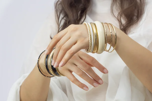 Girl's hands with golden bracelets — Stock Photo, Image