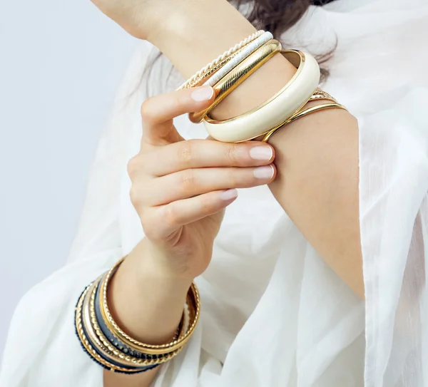 Mädchenhände mit goldenen Armbändern — Stockfoto