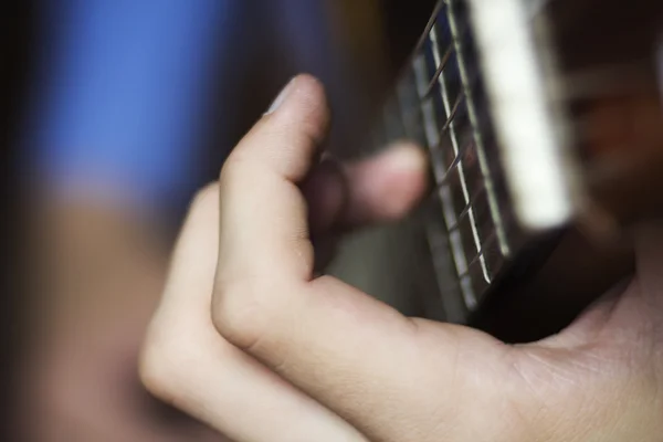 Male's hand on a classical guitar fretboard — Stockfoto