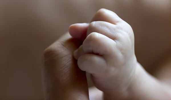 Mano del bambino sul dito di un uomo — Foto Stock