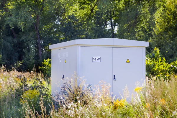 Electric power transformer in a meadow — Stock Photo, Image