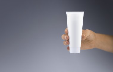 Kadın eli beyaz plastik tüp ile