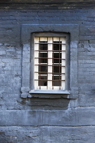 Vergitterte Fenster an einem alten Backsteingebäude — Stockfoto