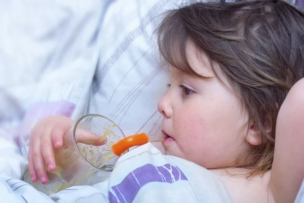 Sick little girl drink juice through a straw — Stock Photo, Image