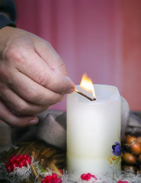 Die Hand des Mannes zündet eine Kerze an — Stockfoto