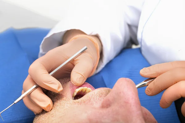 Le dentiste examine les dents du patient — Photo