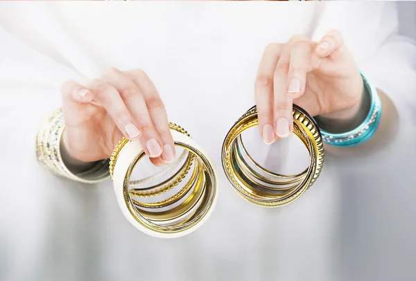 Mädchenhände mit goldenen Armbändern — Stockfoto