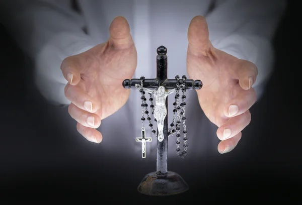 As mãos do homem com crucifixo e um rosário preto — Fotografia de Stock