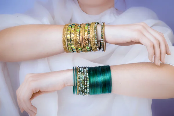 Manos de niña con pulseras de oro — Foto de Stock