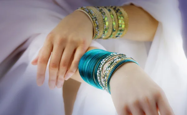 Mãos de menina com pulseiras douradas — Fotografia de Stock