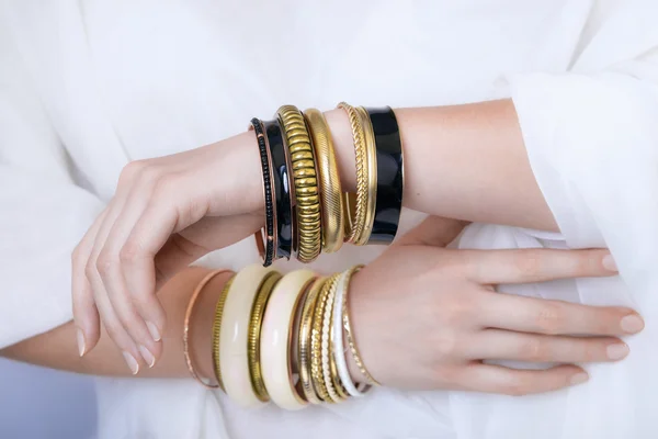 Ragazza mani con bracciali d'oro — Foto Stock